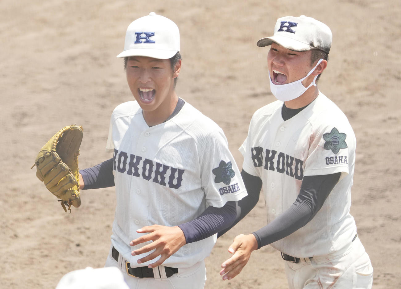 9回、笑顔でベンチに戻る興国・大江遼也（左）と迎える田坂祐士（撮影・清水貴仁）