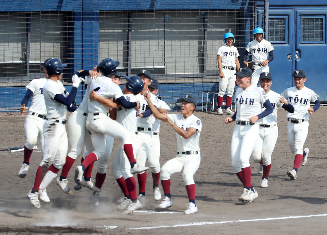 9回裏大阪桐蔭2死三塁、池田の左前サヨナラ適時打で優勝を決め笑顔で生還した繁永（左から4人目）と抱き合うナイン（撮影・加藤哉）