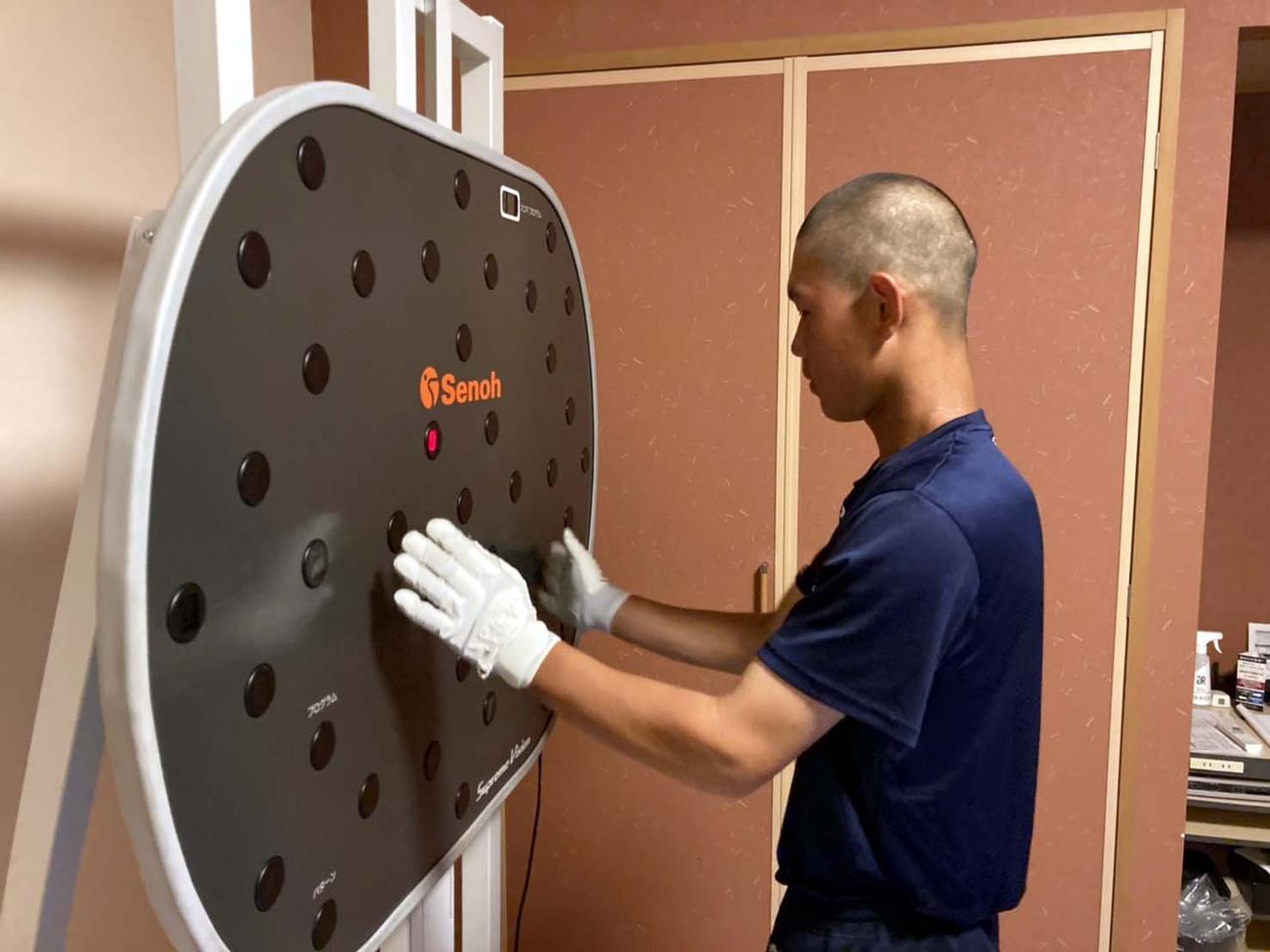 宿舎に持ち込んだビジョントレーニングのマシンを用いて目の鍛錬をする帯広農・西川健生（帯広農提供）