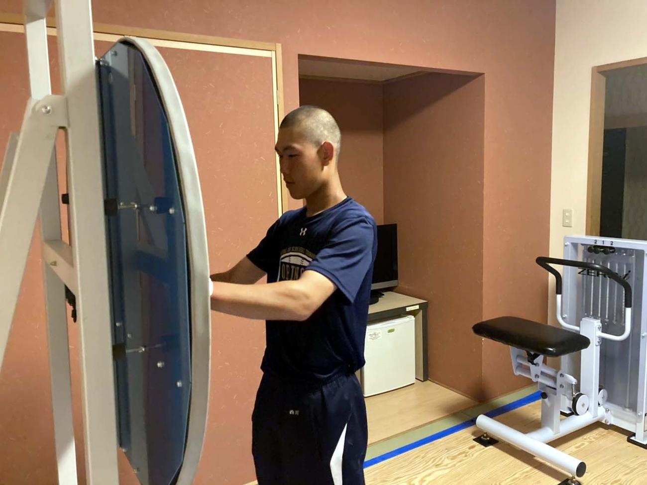宿舎に持ち込んだビジョントレーニングのマシンを用いて目の鍛錬をする帯広農・西川健生（帯広農提供）