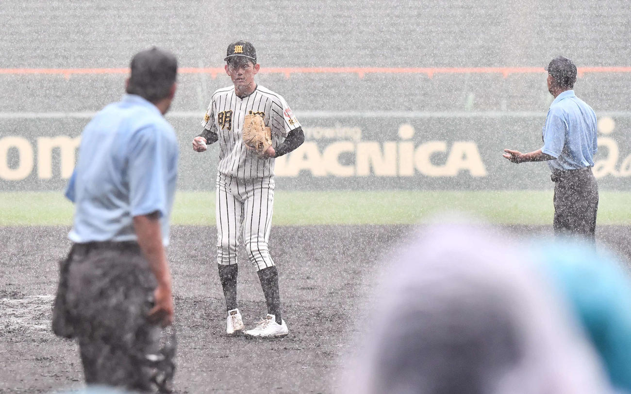 帯広農対ノースアジア大明桜　突然の大雨で中断となり審判にベンチに戻るよう促されるノースアジア大明桜・風間（撮影・上田博志）