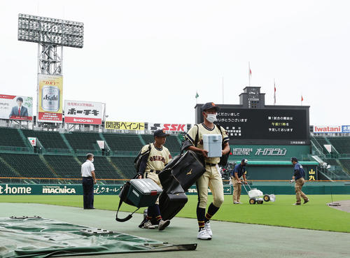午前9時半過ぎ、第1試合が午前11時開始となりグラウンドを整備する阪神園芸とベンチに荷物を運ぶ帯広農の選手たち（撮影・垰建太）