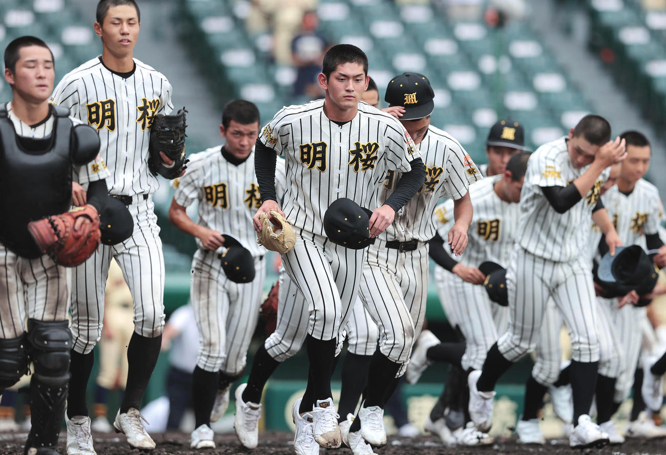 帯広農に勝利し、応援団のもとへ駆け出す風間（中央）らノースアジア大明桜ナイン（撮影・前田充）