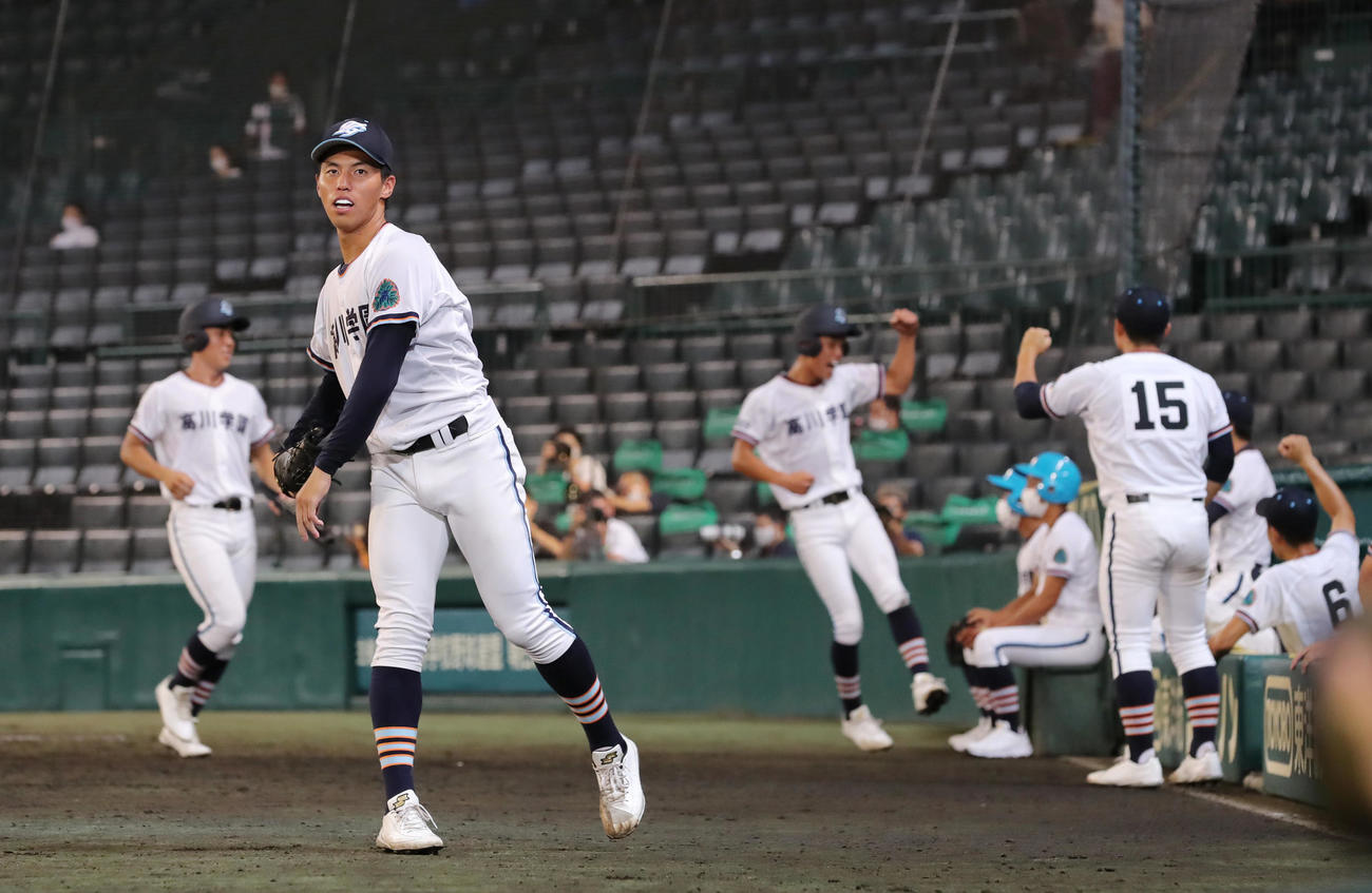 小松大谷対高川学園　8回裏高川学園2死一、三塁、源の適時打で追いつき投球練習を行う河野（手前）の表情にも笑みがこぼれる（撮影・垰建太）