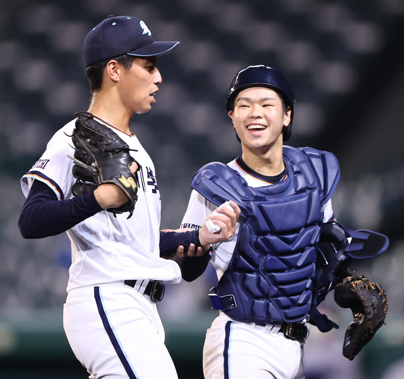 小松大谷対高川学園　3回表の登板を終えた高川学園先発の河野（左）の左手を持ち笑顔で鼓舞する山崎（撮影・垰建太）