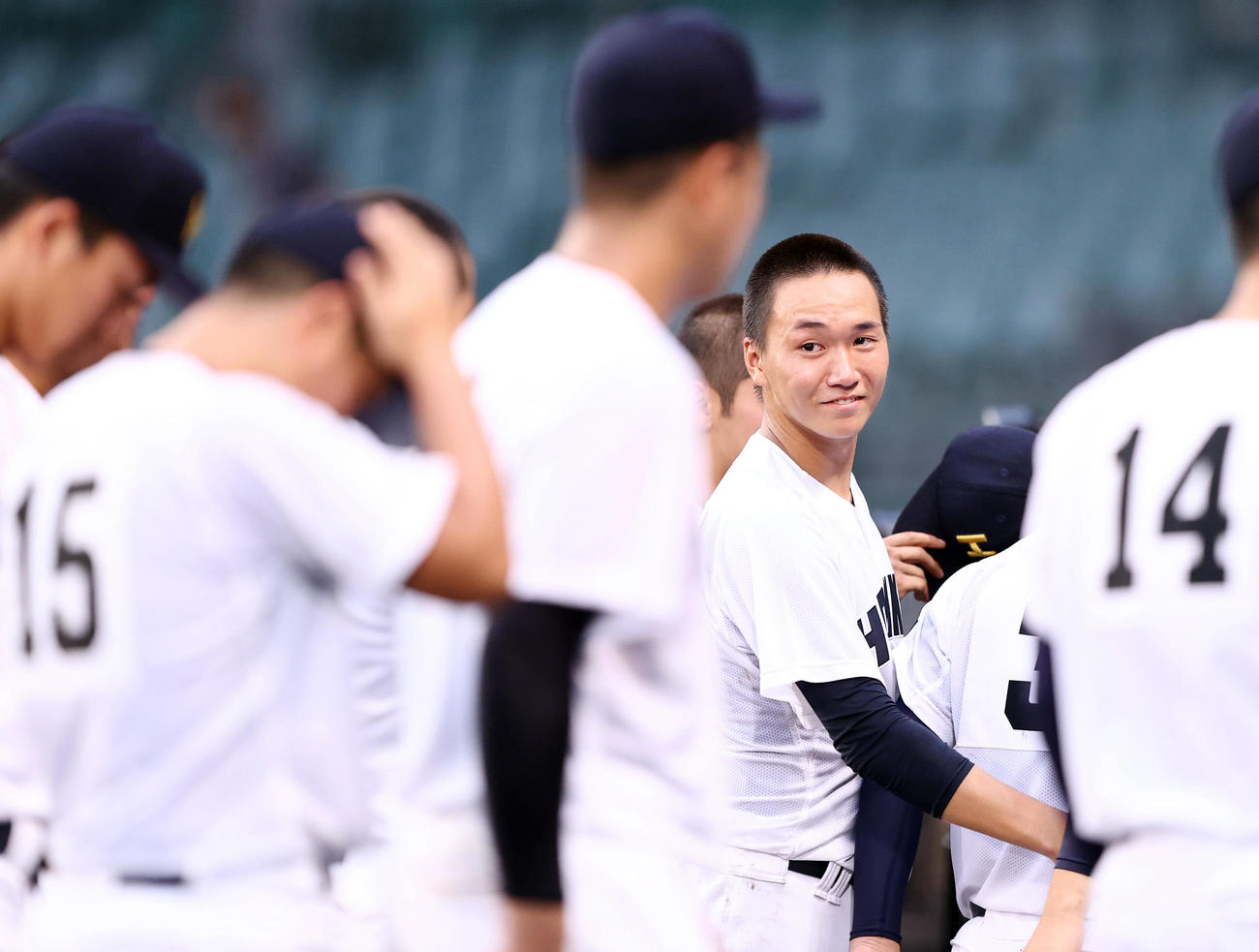 神戸国際大付対北海　試合に敗れ目に涙を浮かべるも笑顔で落ち込むナインを鼓舞する北海・木村（右）（撮影・垰建太）