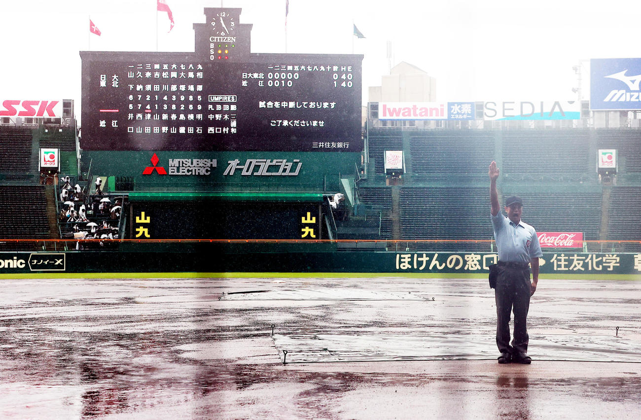 日大東北対近江　5回裏近江2死満塁の場面で降雨のため中断となり、中西球審がノーゲームをコールする（撮影・野上伸悟）