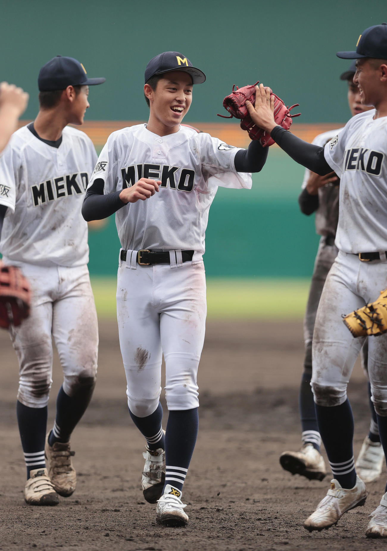 三重対樟南　完封勝利を挙げ笑顔でタッチを交わす三重・上山（中央）（撮影・前田充）
