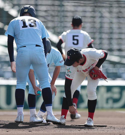 近江対日大東北　1回表近江無死、井口の打球が右足に当たり痛がる吉田（手前右）（撮影・前田充）