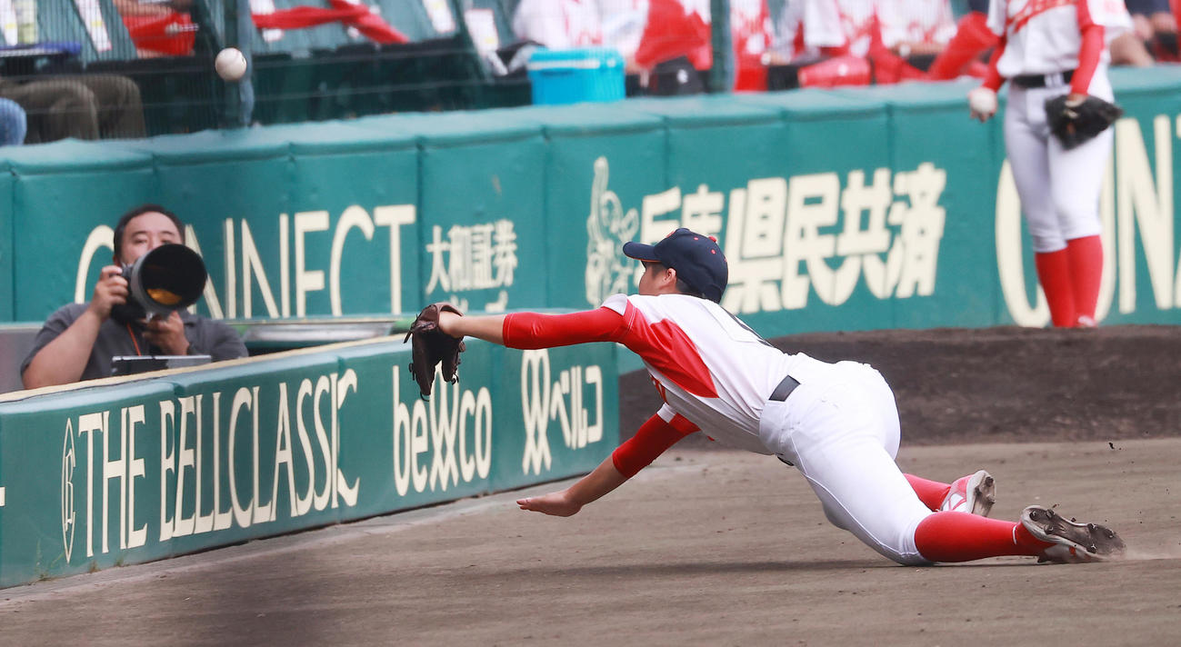 高知中央対神戸弘陵　1回裏神戸弘陵2死、島野の三邪飛に飛び込みフェンスに頭をぶつける細川（撮影・野上伸悟）