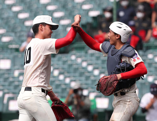 智弁学園対日本航空　日本航空に勝利してお互いの手首をタッチする投手・小畠（左）と捕手・植垣（撮影・白石智彦）