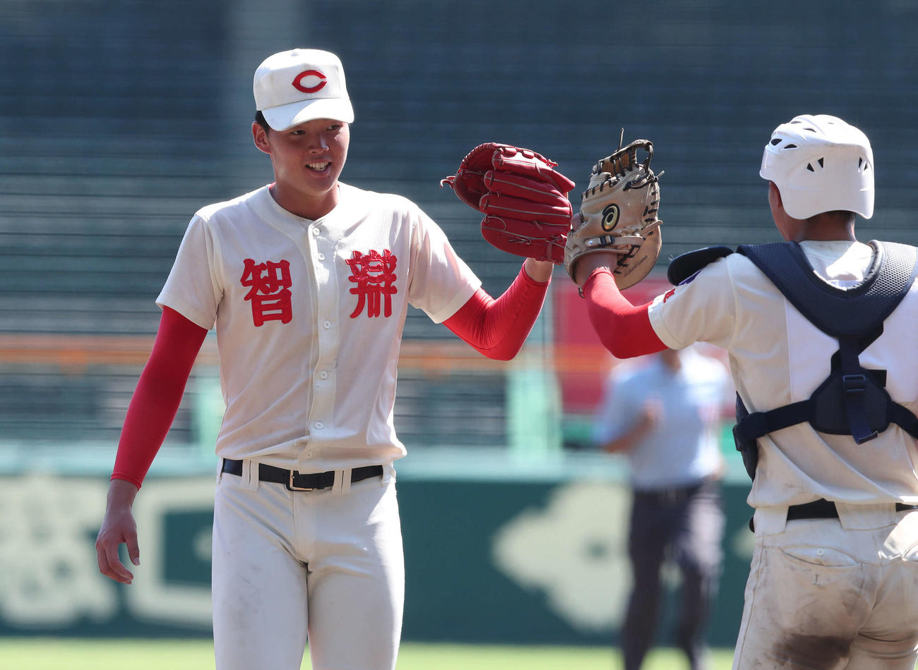 智弁学園対京都国際　決勝進出を決めグラブタッチを交わす小畠（左）と捕手植垣（撮影・白石智彦）