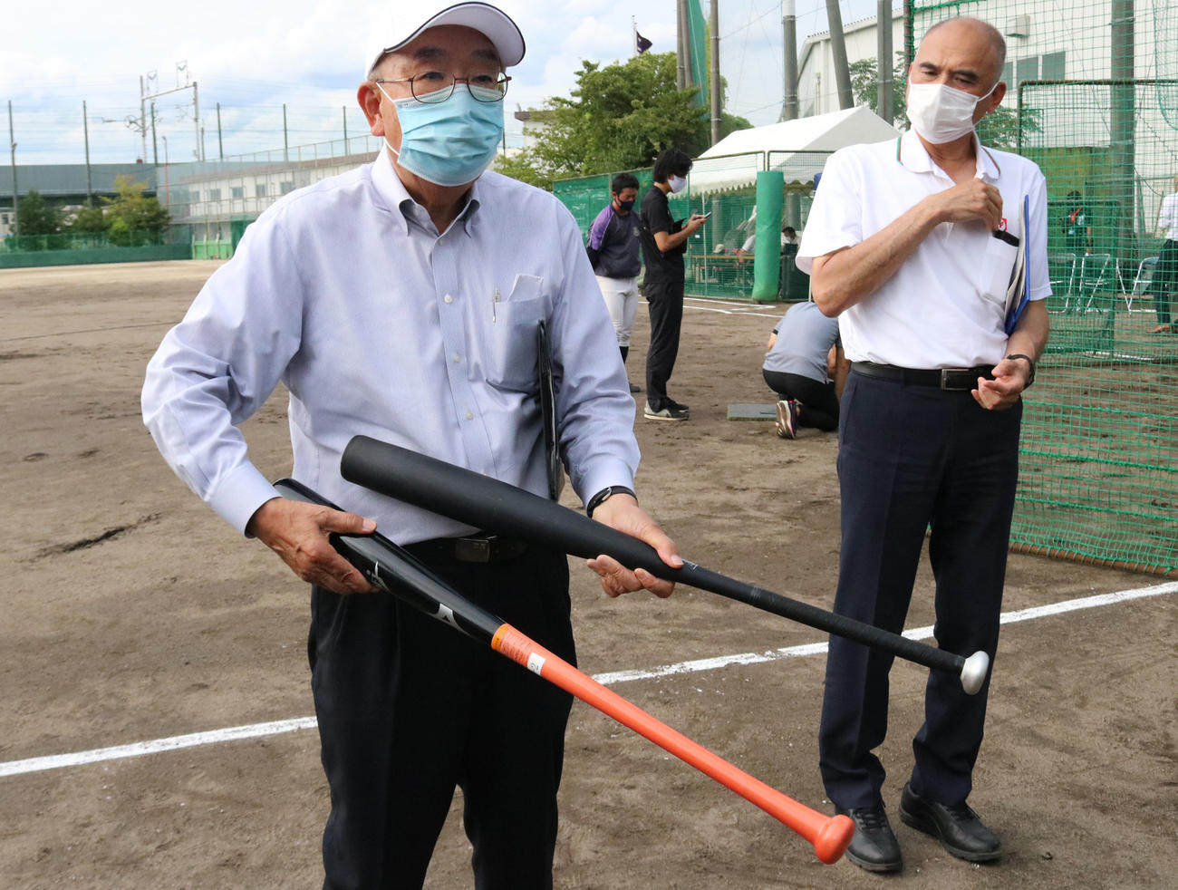 日本高野連の田名部顧問は木製バットと新金属バットを持ち説明する（撮影・林亮佑）