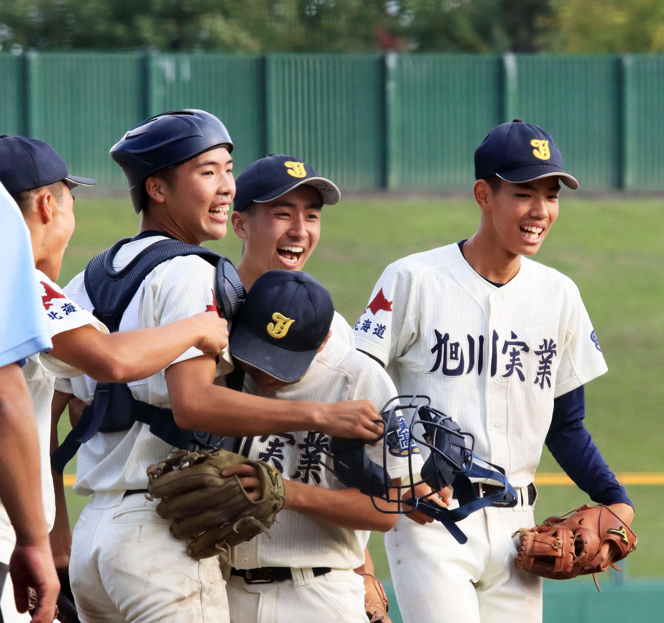 勝利を喜ぶ旭川実・鈴木（左から2人目）と9回に登板した佐々木（同3人目）（撮影・保坂果那）