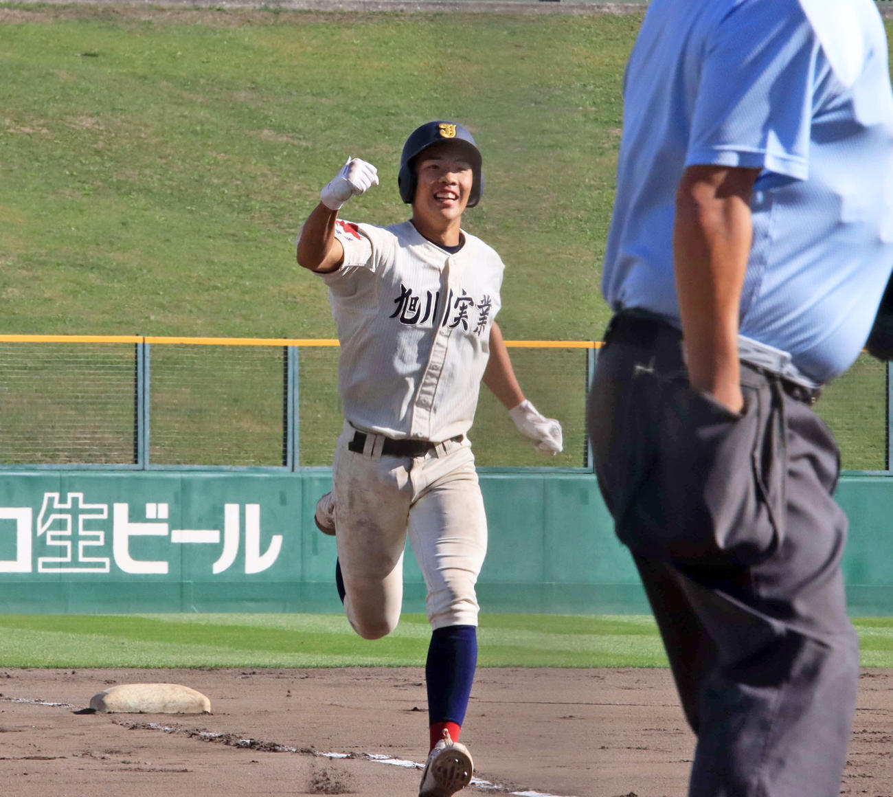 6回無死、勝ち越しのソロ本塁打を放ち笑顔で生還する旭川実・鈴木（撮影・保坂果那）