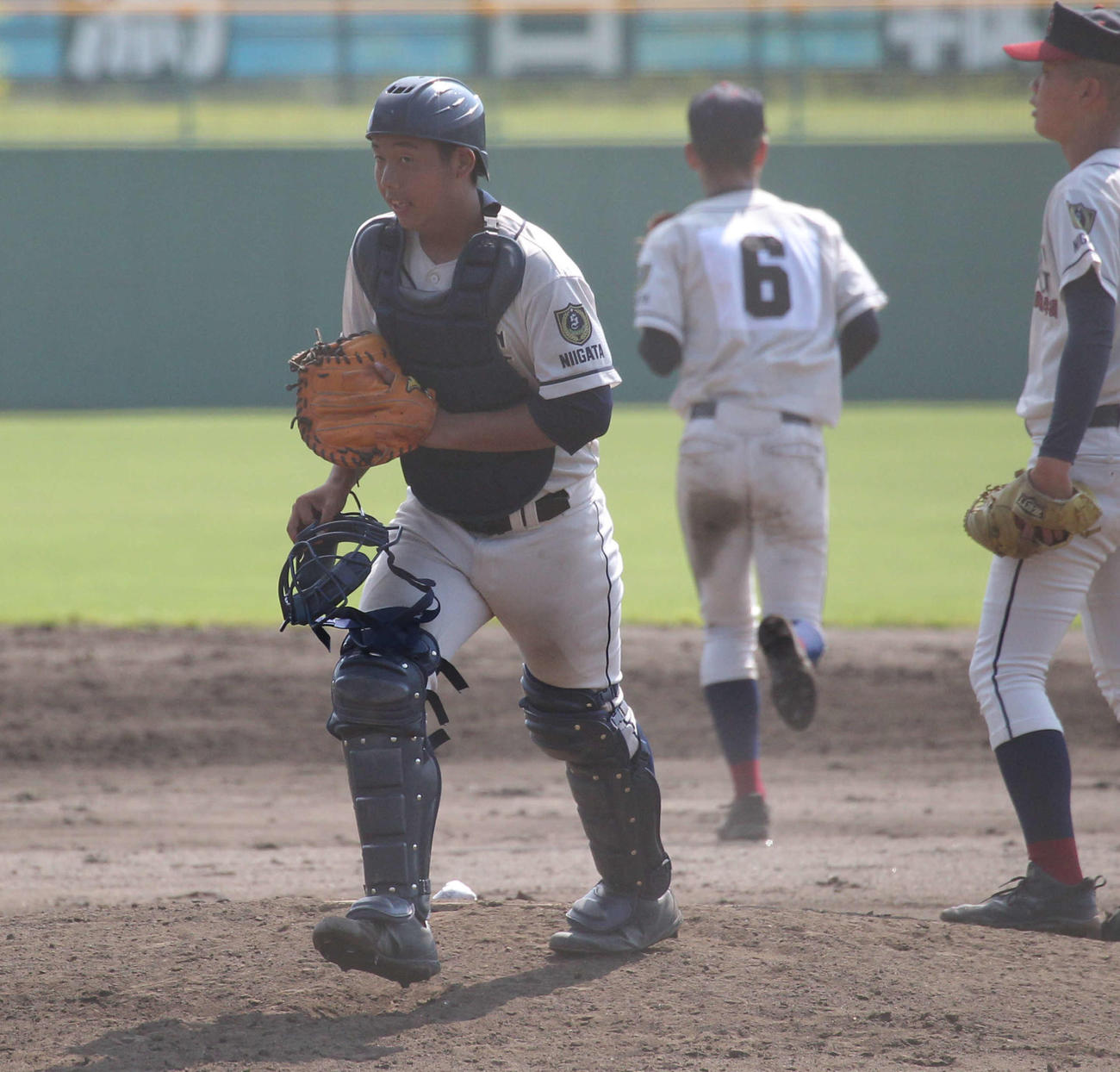 マウンド上の円陣から本塁に戻る関根学園の清水捕手