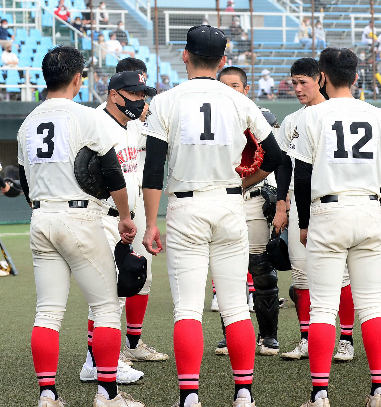 イニング間に選手を鼓舞する日大三島・永田監督（左から2人目）