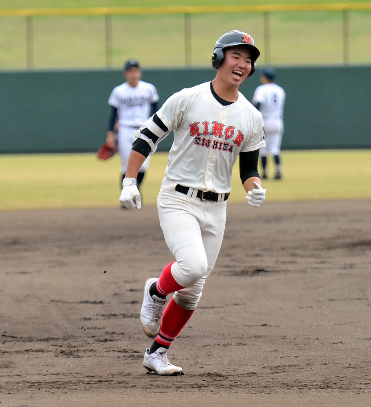 6回裏、満塁本塁打を放って笑顔でベースを回る日大三島・松永