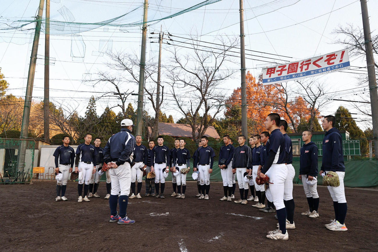 「甲子園行くぞ！」の横断幕を背に野村監督（左）の話しを聞く伊吹ナイン（撮影・加藤哉）