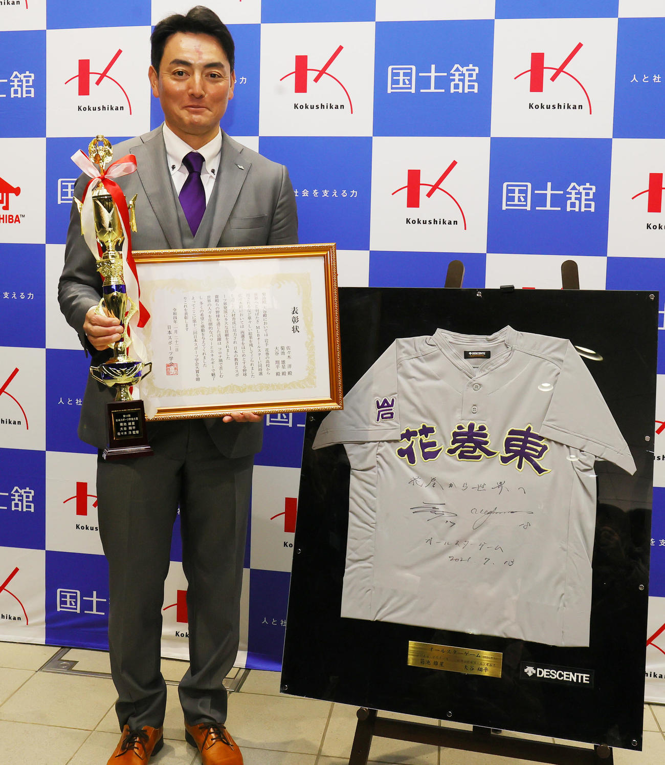 マリナーズ菊池、エンゼルス大谷とともに日本スポーツ学会大賞を受賞した花巻東・佐々木監督は、昨年のMLBオールスター出場時の2人のサインが入ったユニホームと記念撮影（撮影・野上伸悟）