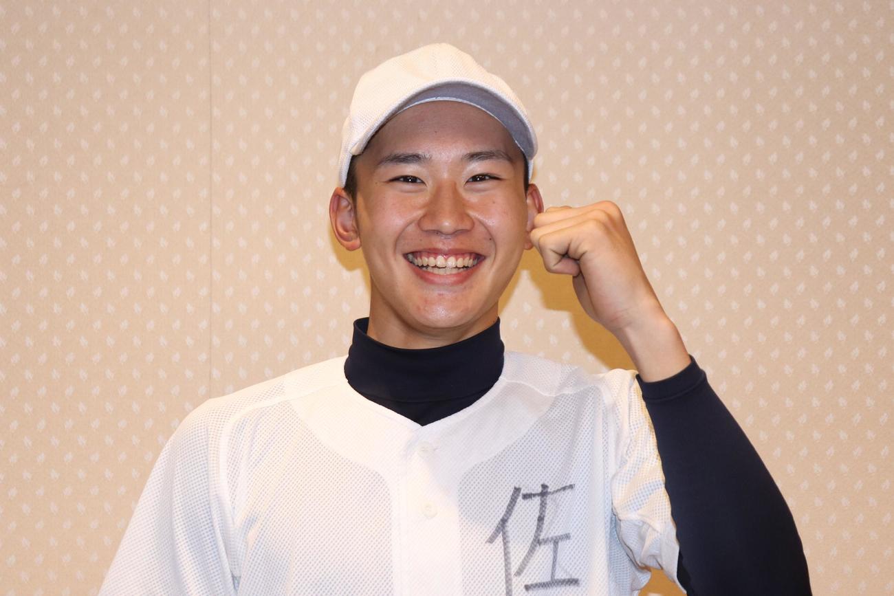 笑顔で写真撮影に応じた駒場学園・佐藤夏月投手（撮影・阿部泰斉）