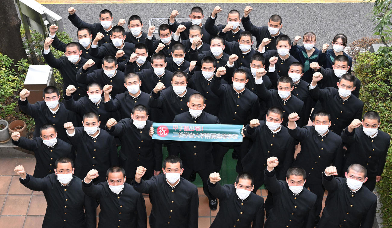 甲子園出場を祝う記念のバナーを手にする二松学舎大附・小林幸男主将（中央）と記念撮影する選手たち（撮影・滝沢徹郎）