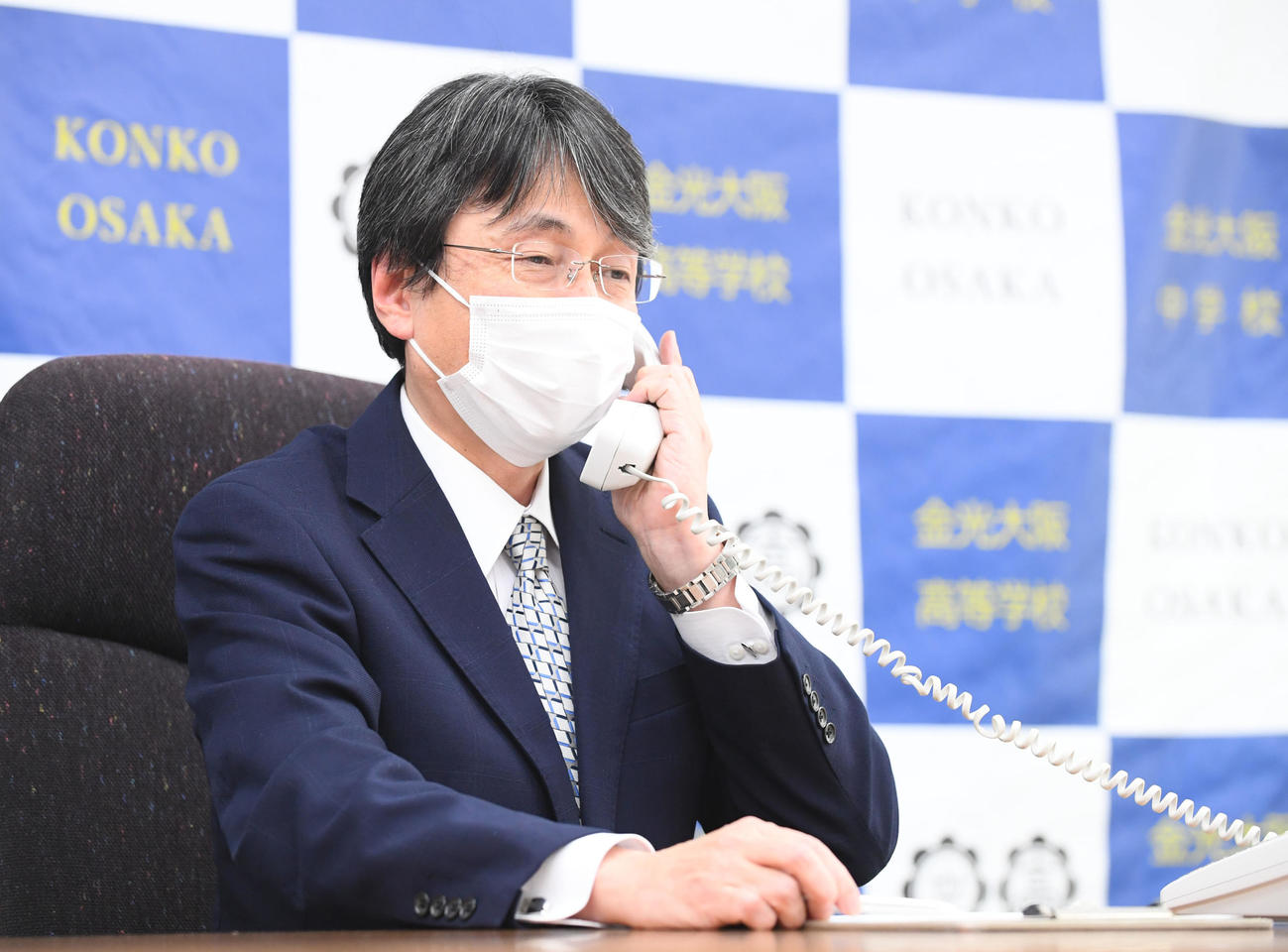 センバツ出場決定の電話を受けとる金光大阪の西村公延校長（撮影・滝沢美穂子）
