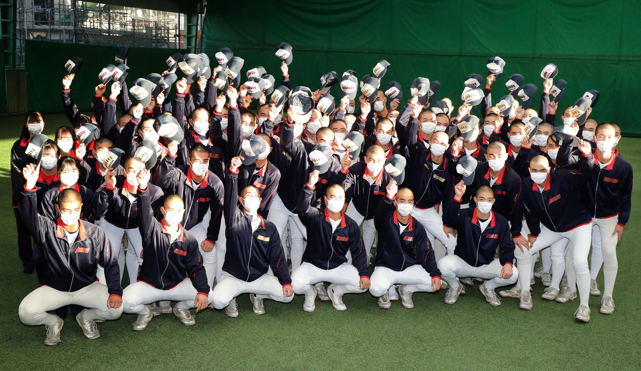 センバツ出場決定で、帽子を掲げて記念撮影する浦和学院の選手たち（撮影・浅見桂子）