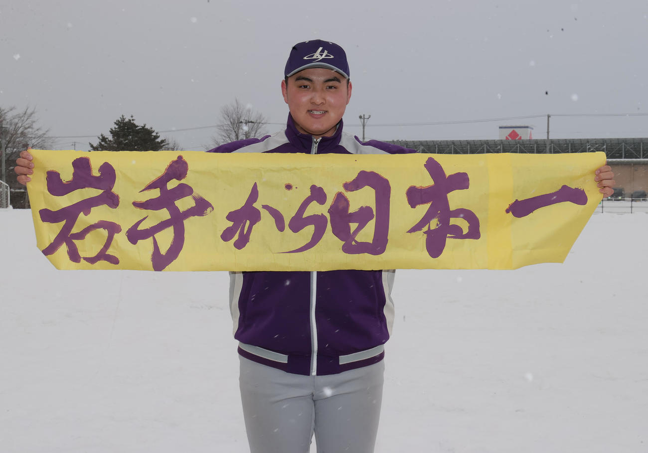 4年ぶり4度目のセンバツ出場が決まり、書道部から贈られた「岩手から日本一」の書を手に笑顔を見せる花巻東・佐々木麟（撮影・野上伸悟）