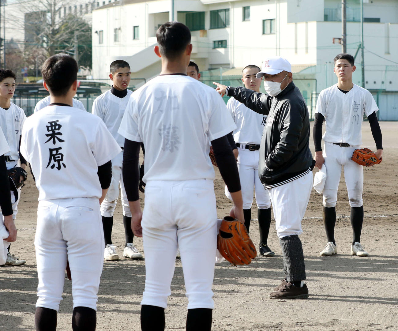 永田監督（右から2人目）の話を聞く日大三島ナイン