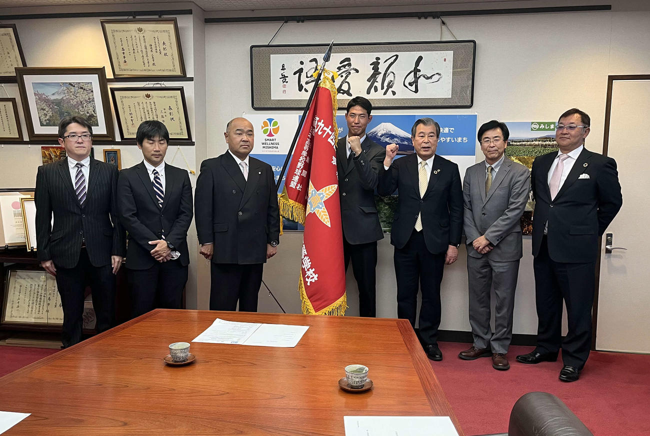 豊岡市長（左から5人目）と記念写真に納まる出席者たち。同3人目が日大三島・永田監督、右隣が加藤主将