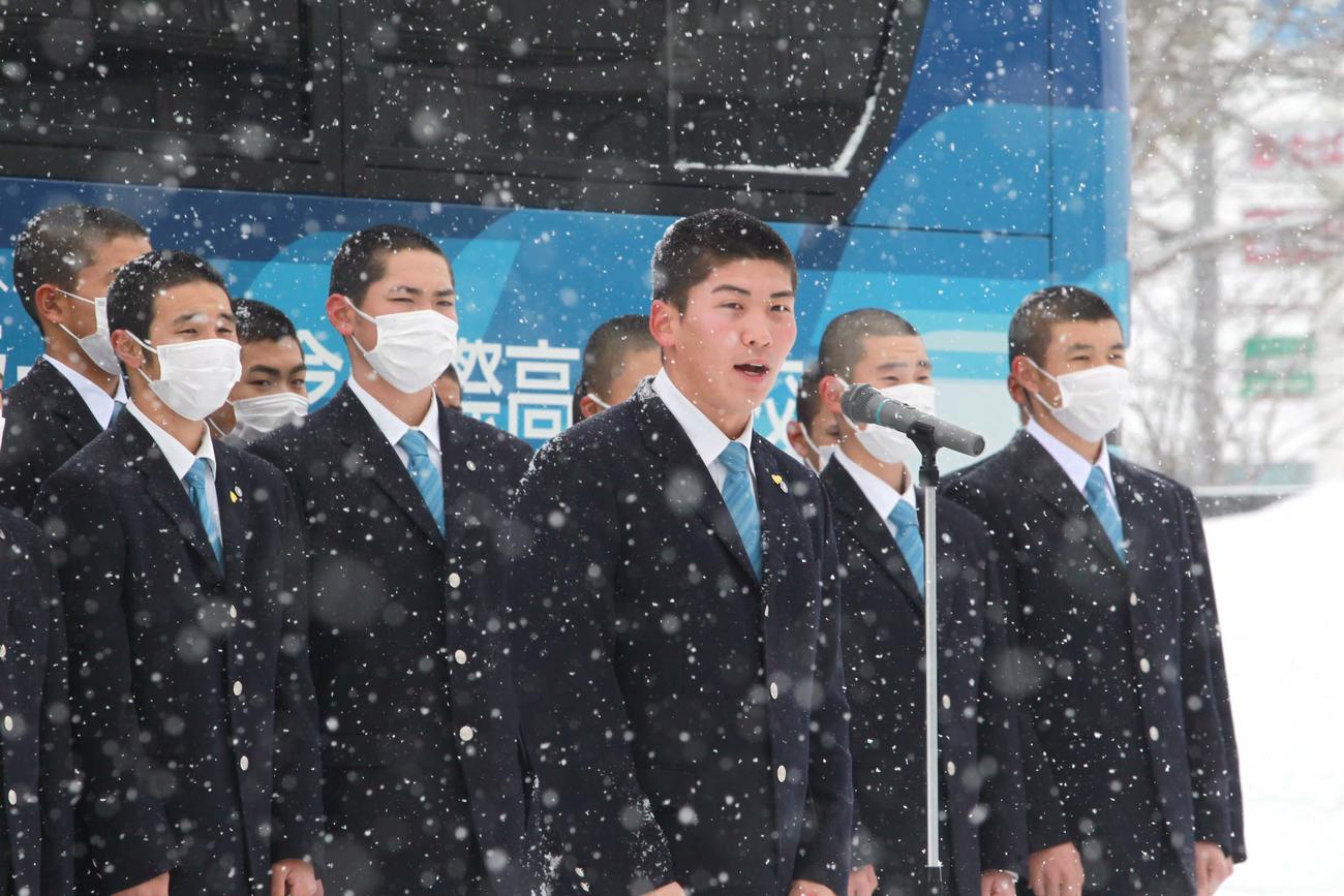 雪の中、深川市民に向けあいさつするクラークの白取太郎主将（中央）（同高提供）