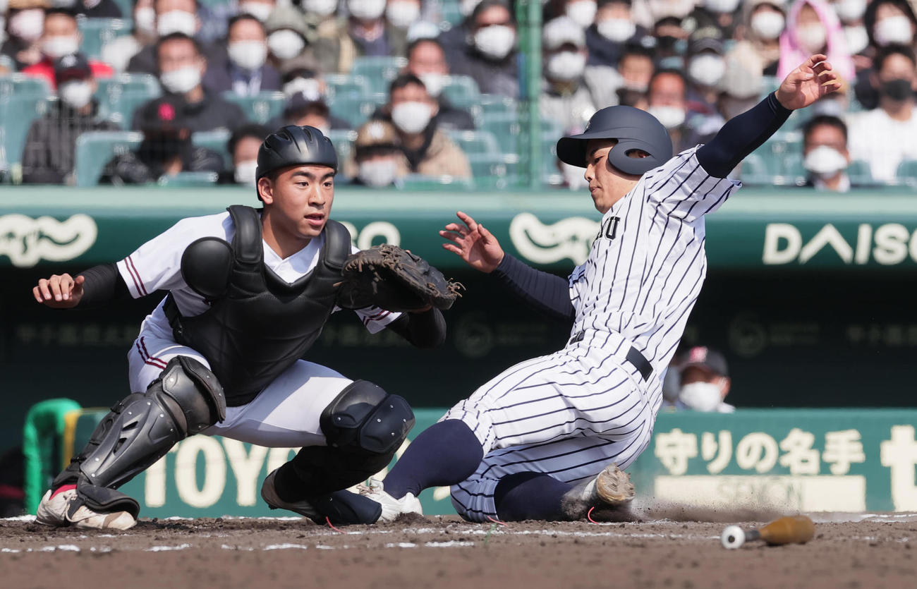 九州国際大付対広陵　2回表九州国際大付2死満塁、黒田の右前2点適時打で生還する白井。捕手大山（撮影・野上伸悟）