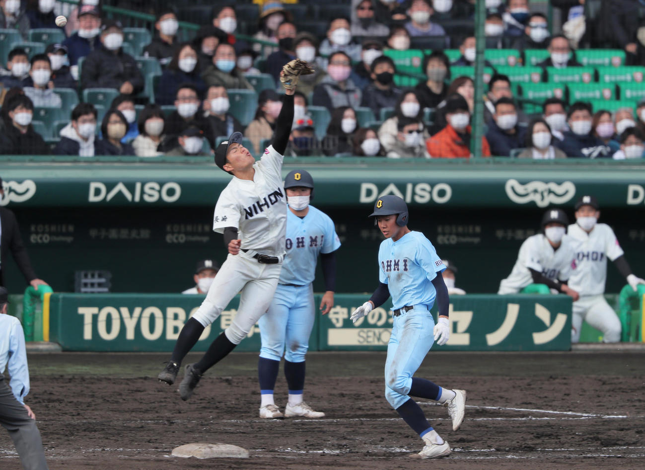 近江対長崎日大　タイブレーク13回表近江無死一、二塁、石浦（右）のバントを投手川副が一塁悪送球する。左は一塁手白川（撮影・上山淳一）