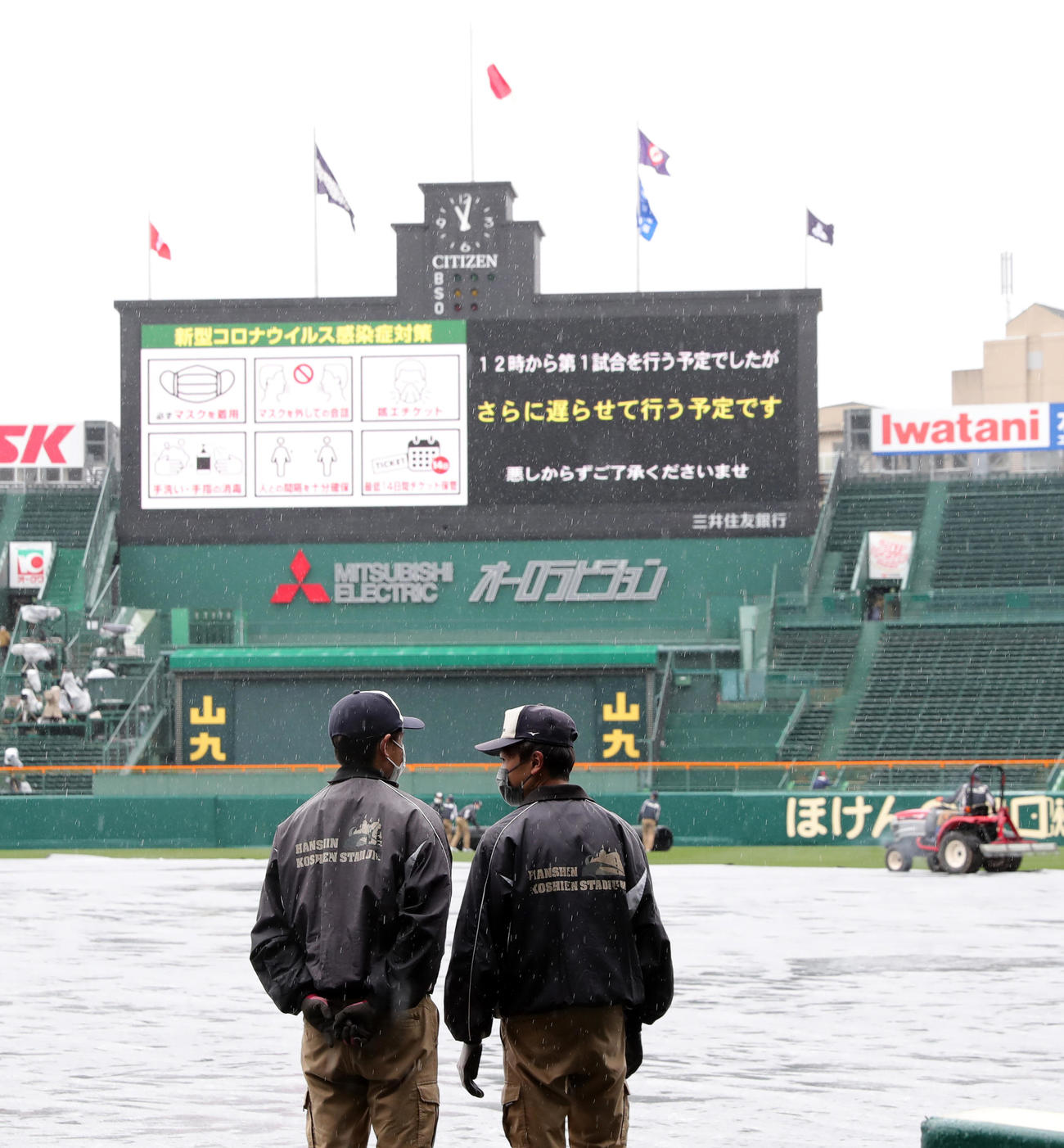午前11時頃、雨足が弱まらず第1試合開始が遅れることとなりグラウンドを見つめながら話す阪神園芸（撮影・垰建太）