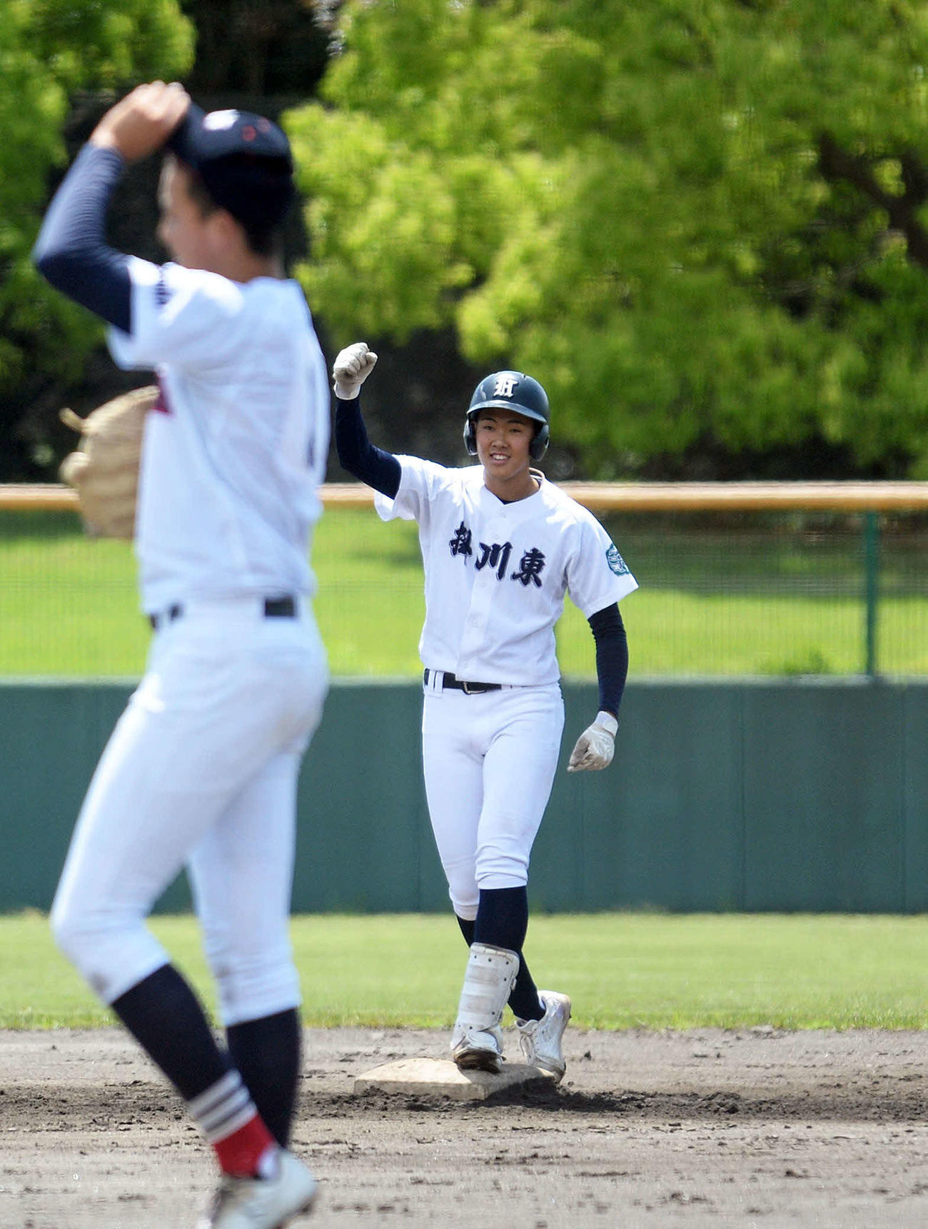 7回に二塁打を放ち、ガッツポーズする掛川東の宇田。手前は駿河総合の原崎翔