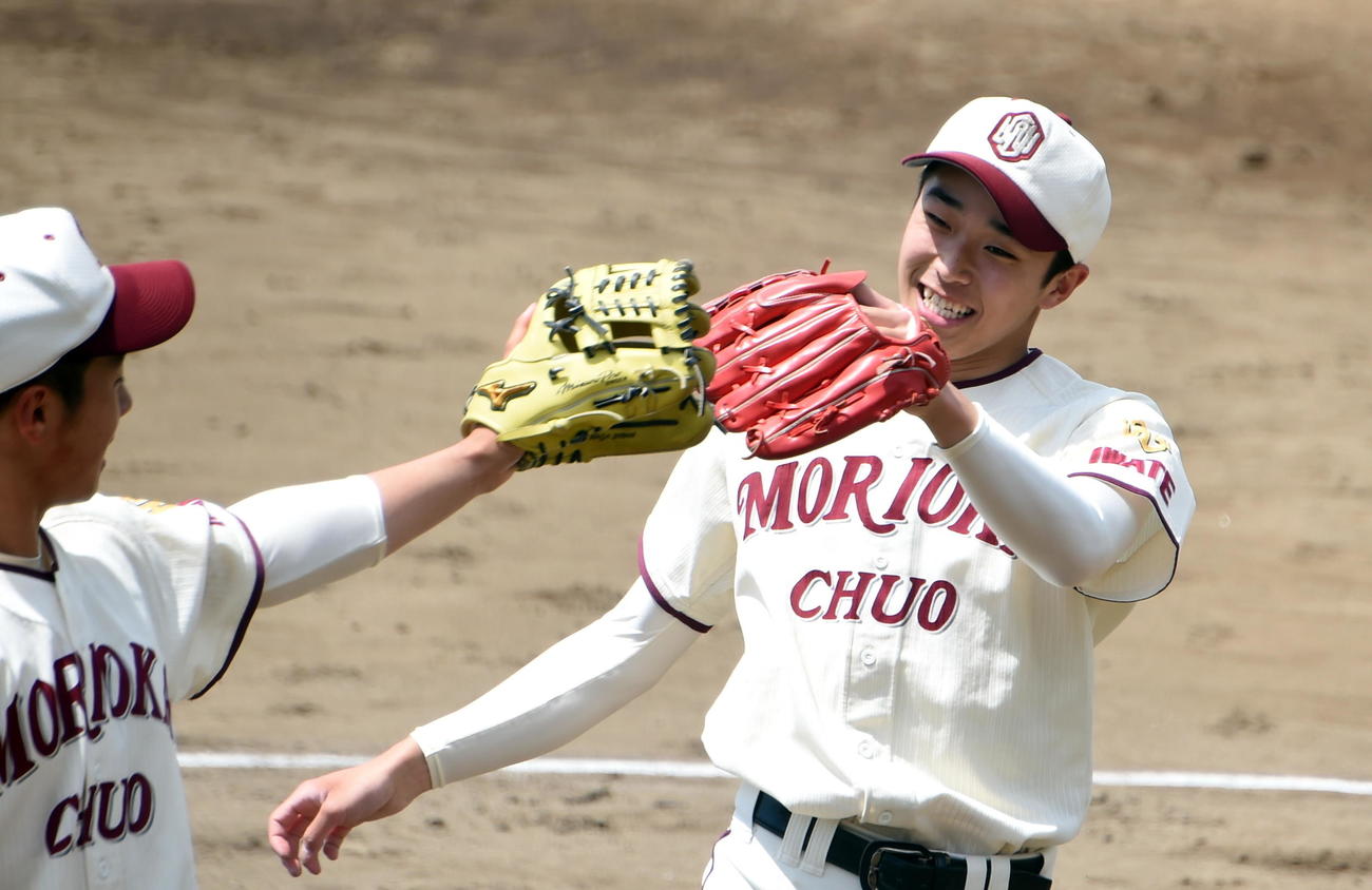 盛岡中央対盛岡一　笑顔でグラブタッチしながらベンチに引き揚げる盛岡中央・斎藤（右）（撮影・山田愛斗）