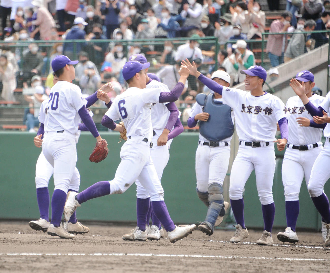 初優勝を決め、タッチをしながら喜ぶ東京学館新潟ナイン