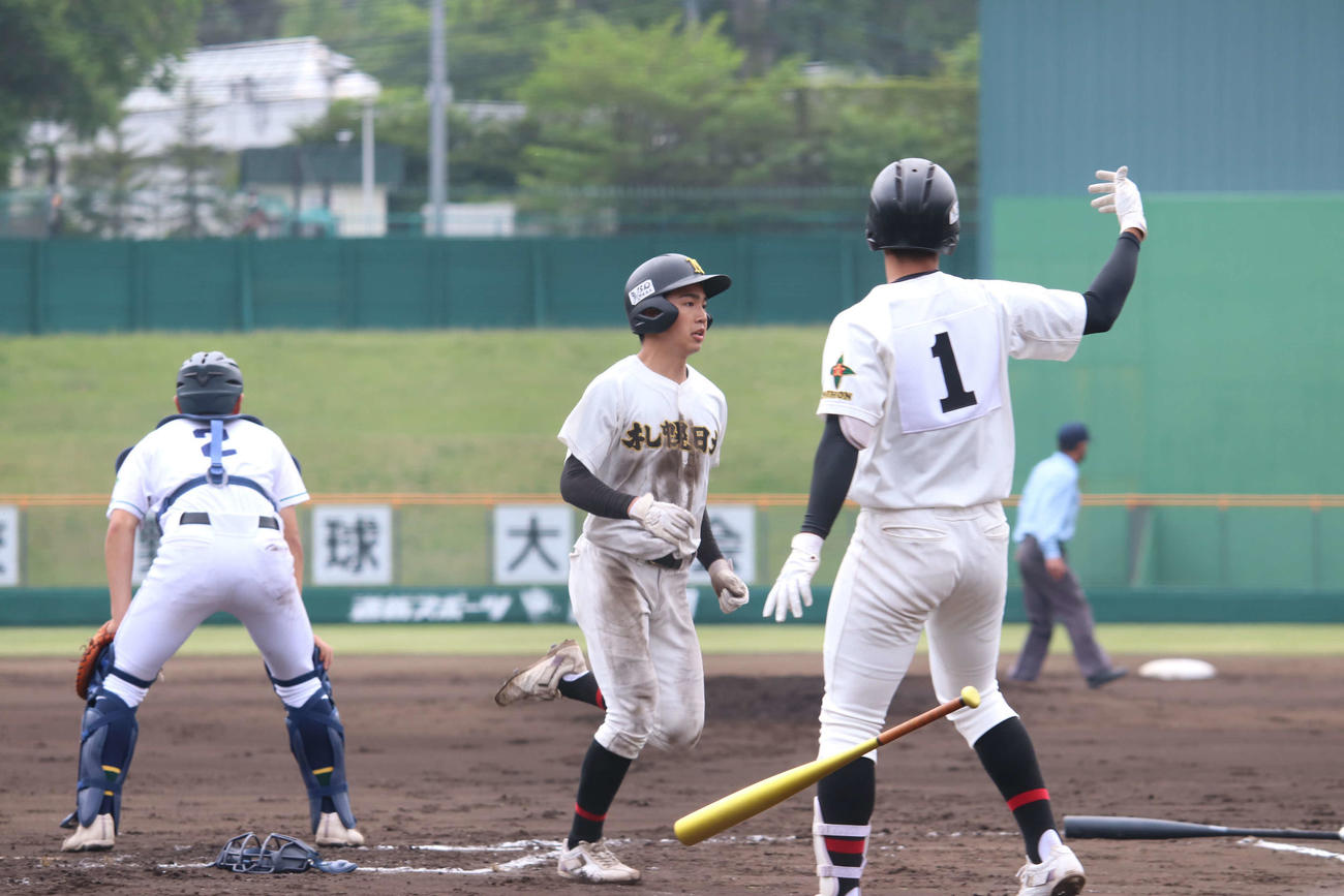 旭川明成対札幌日大　1回裏札幌日大1死二、三塁、4番前川の中前適時打で先制のホームを踏む新田（中央）（撮影・山崎純一）
