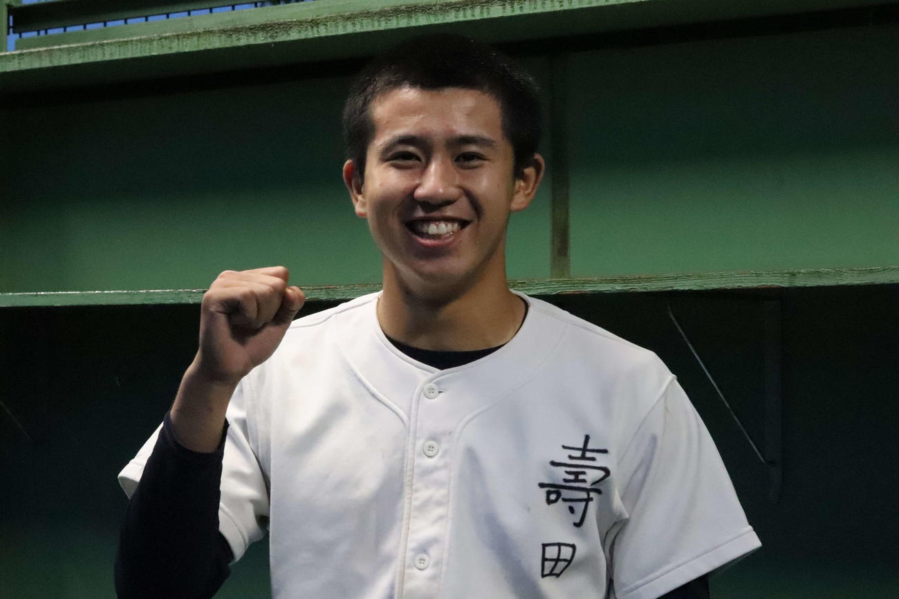 笑顔でポーズをとる早実・寿田主将（撮影・藤塚大輔）