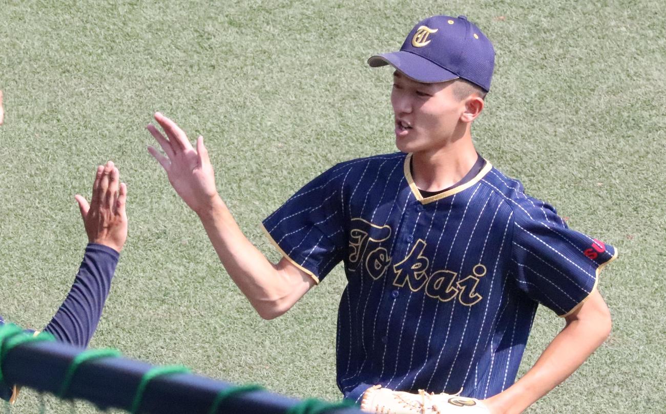 大阪桐蔭対東海大菅生　チームメートとハイタッチする東海大菅生先発の鈴木泰投手（撮影・藤塚大輔）
