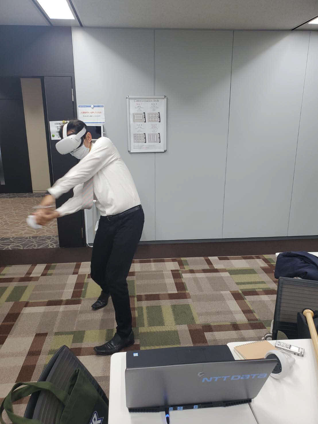 VR技術を活用したNTTデータ社の「V－BALLER」を体験し、スイングする酒井記者