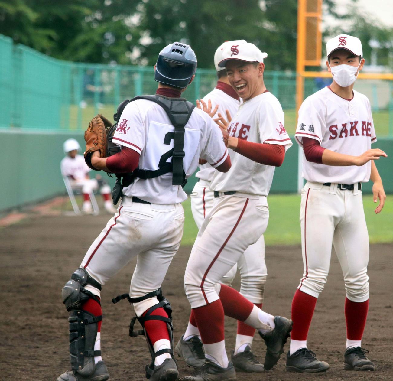 苫小牧中央対室蘭栄　6回2死一塁の場面で一塁走者をけん制で刺し、笑顔でベンチに引き揚げる室蘭栄の住吉（中央）（撮影・永野高輔）