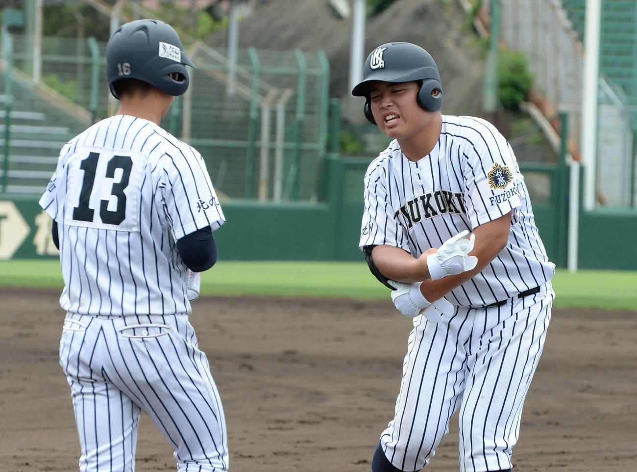 九州国際大付対大和青藍　　2回に右太もも裏に死球を受け、一塁ベース上で苦悶の表情を浮かべる九州国際大付・佐倉（撮影・只松憲）