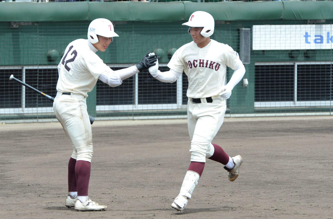 東筑対玄界　東筑・堂満（右）は3回に左越え本塁打を放ち、チームメートをハイタッチ（撮影・只松憲）