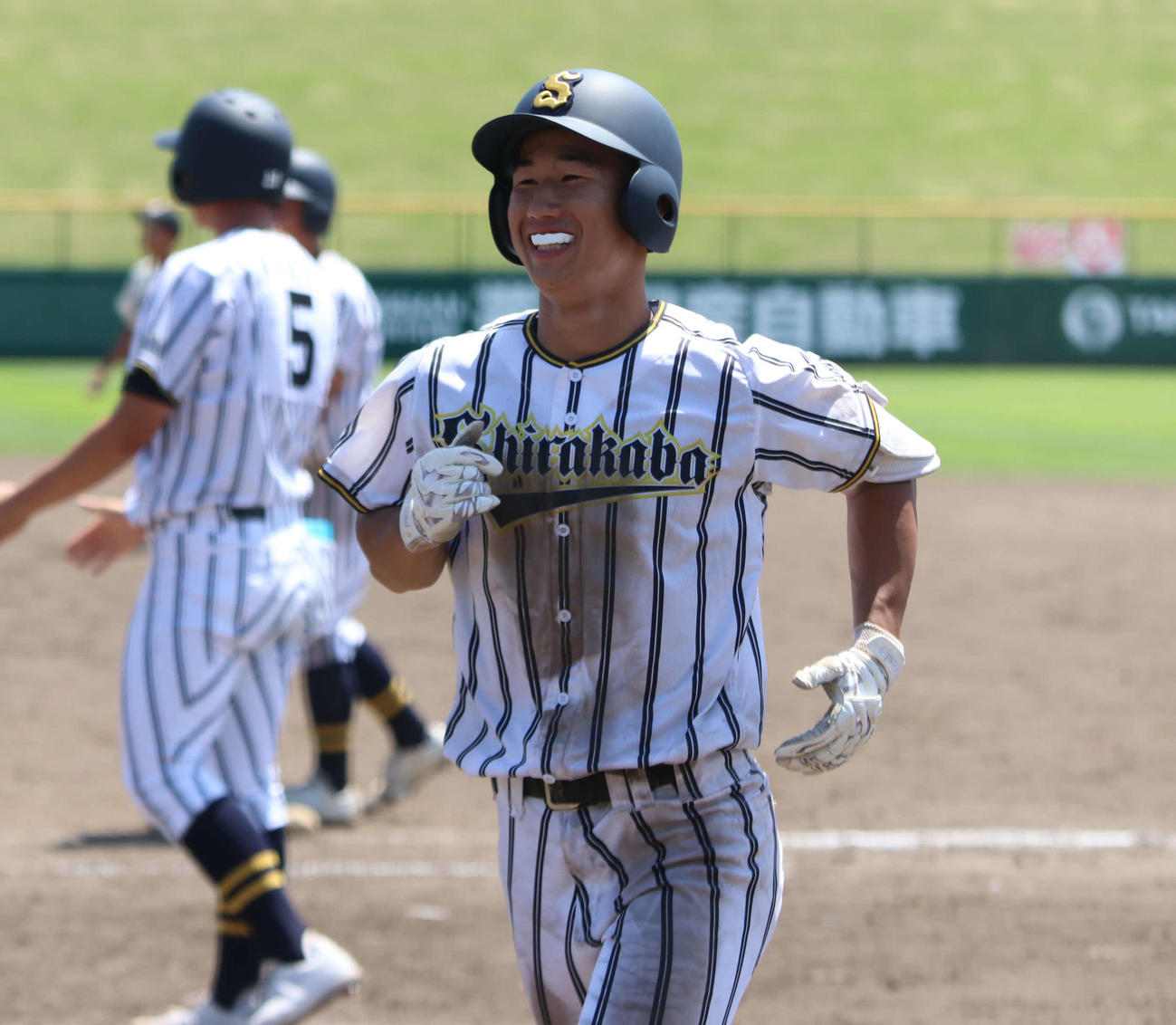 白樺学園対帯広三条　9回表白樺学園無死満塁で中犠飛を放ち、笑顔でベンチに戻る田中主将（撮影・山崎純一）