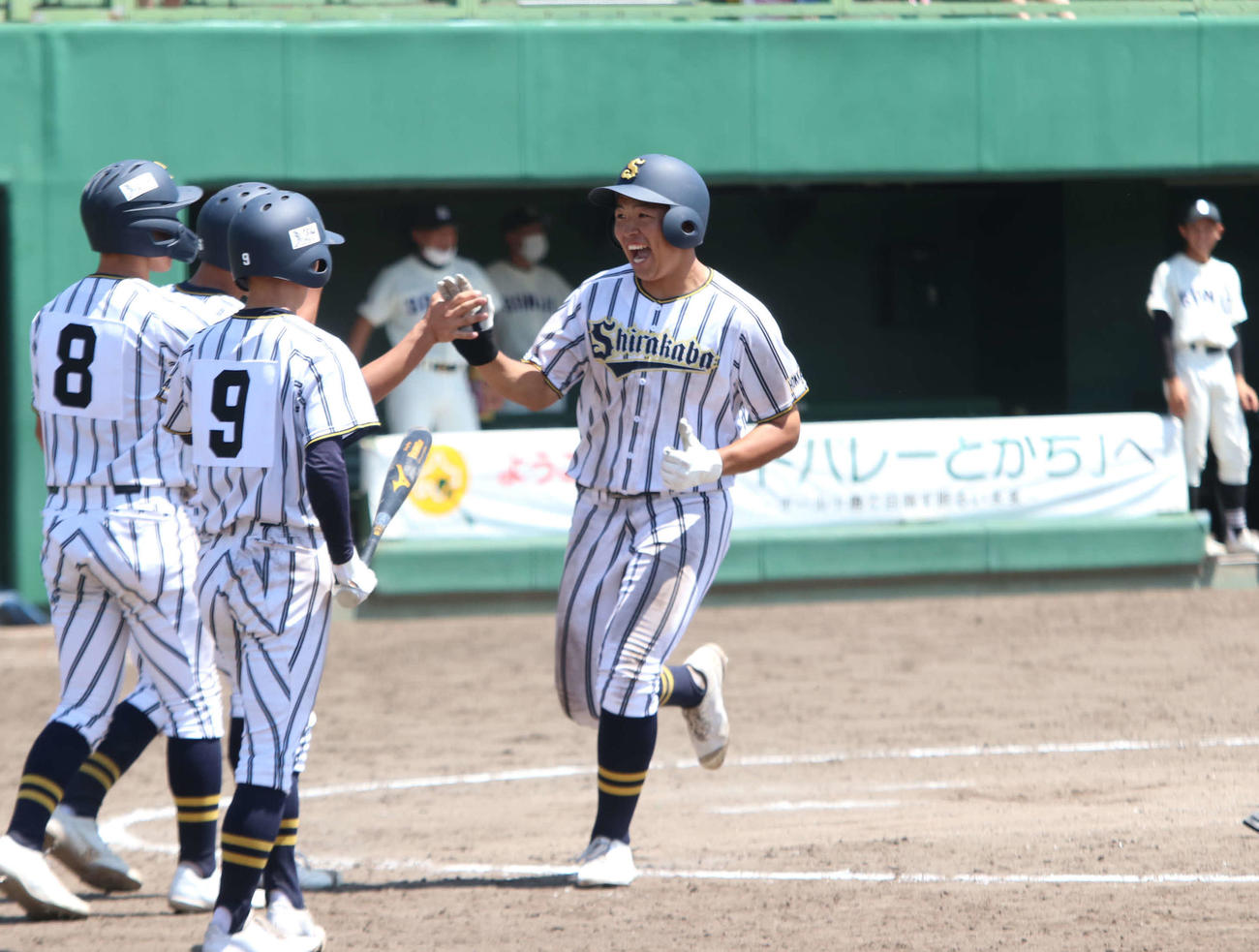 白樺学園対帯広三条　9回表白樺学園1死一、二塁で左越えに本塁打を放ち、生還後にチームメートとハイタッチする矢野（撮影・山崎純一）