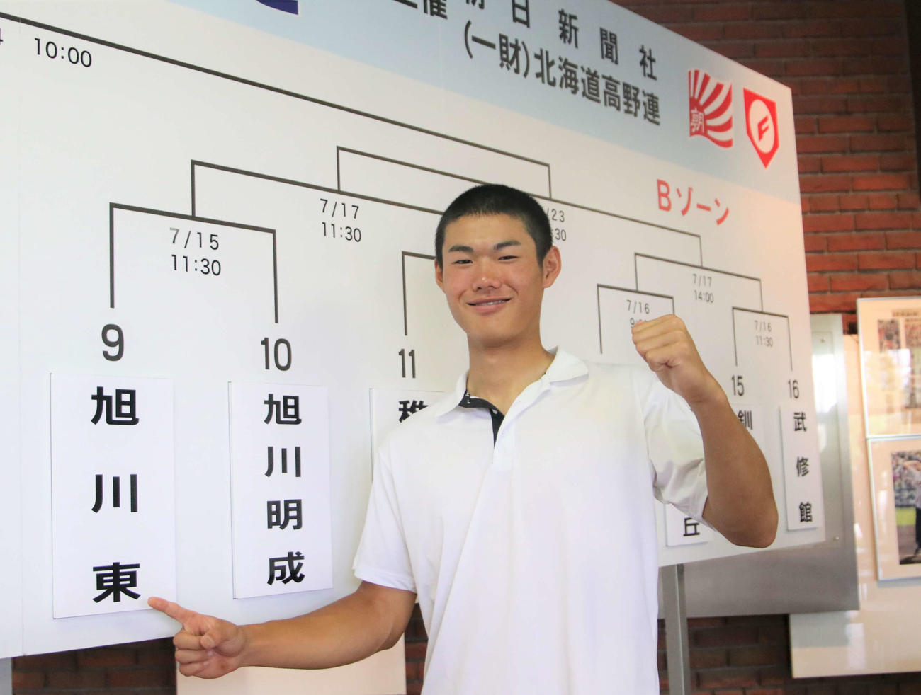 校名を指さす旭川東・今津主将（撮影・山崎純一）