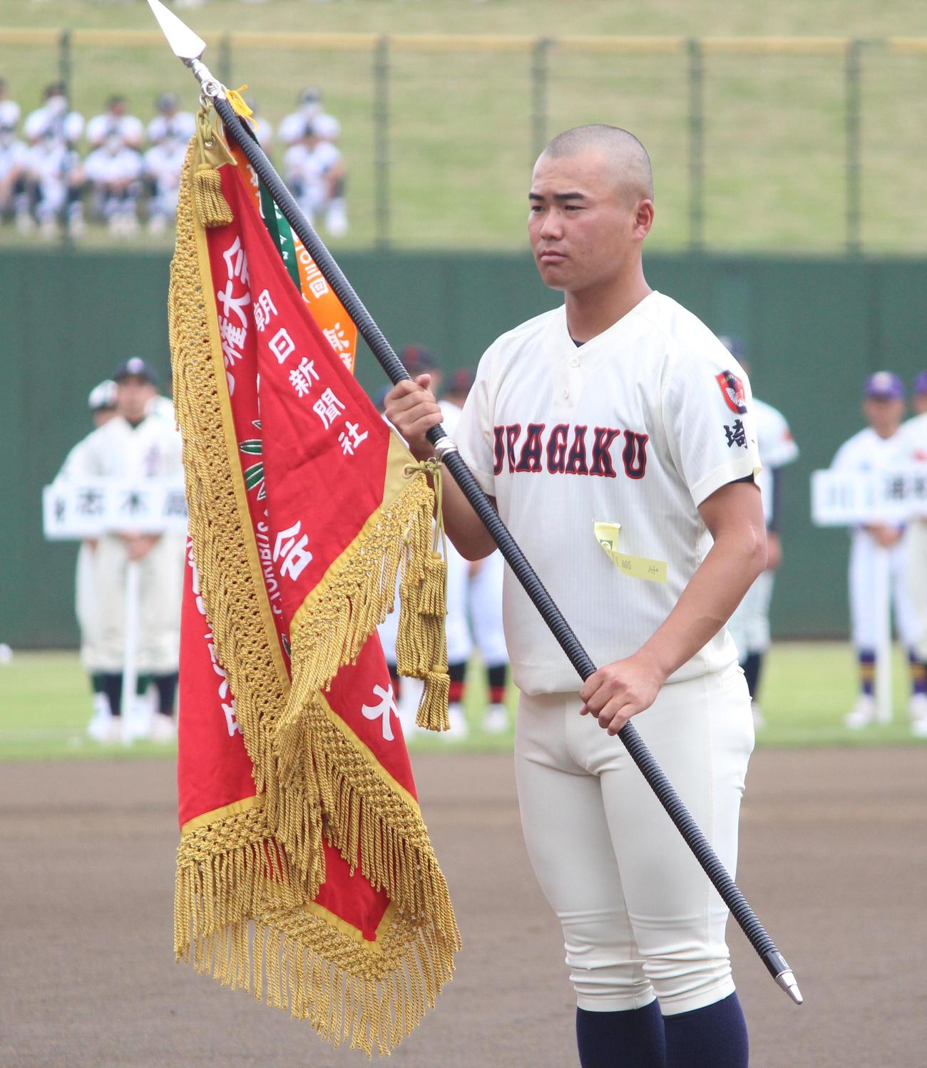 開会式で昨夏の優勝旗を返還する浦和学院の八谷主将（撮影・保坂恭子）