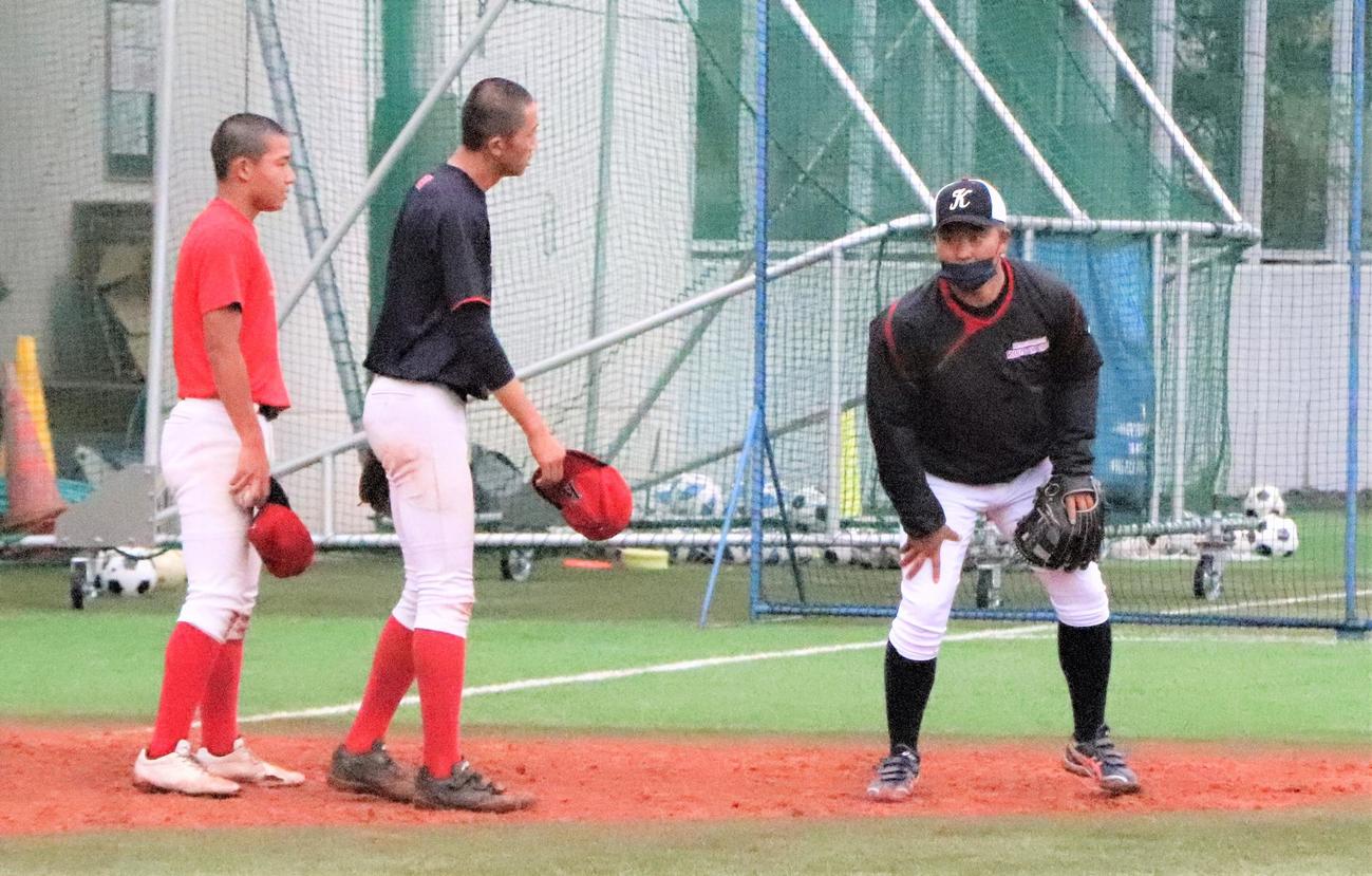 守備練習の合間に選手たちへ熱心に指導する国学院久我山・尾崎監督（撮影・藤塚大輔）
